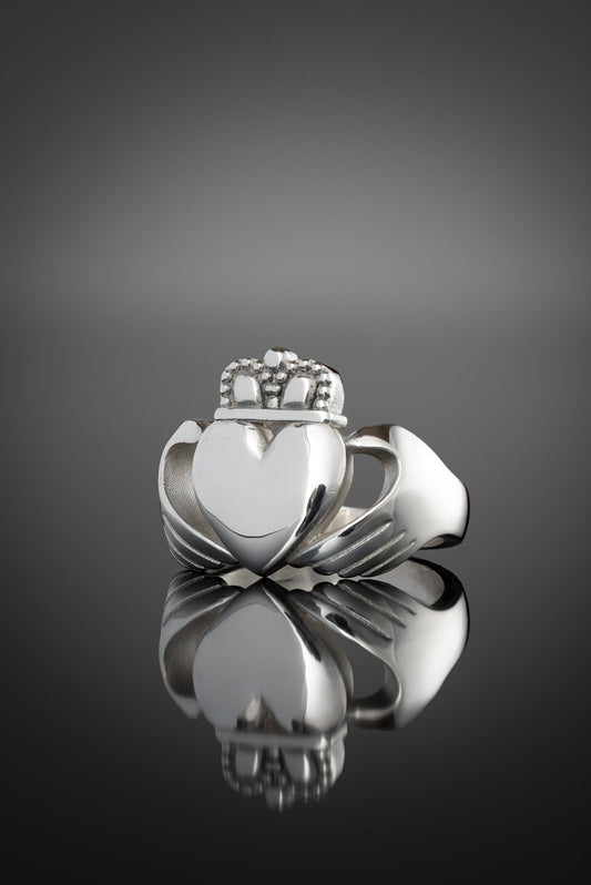 extra large chunky claddagh ring from the side on a black background