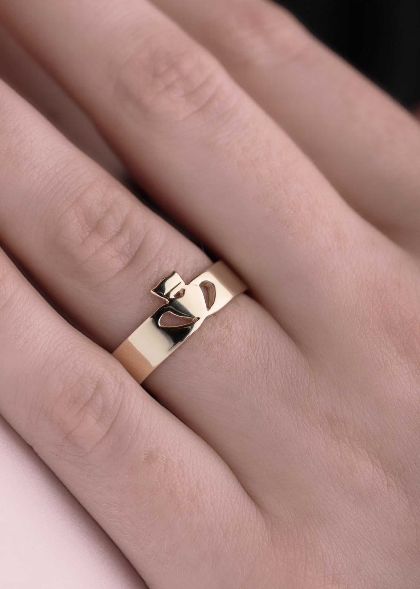 Gold claddagh ring in a modern style on model's hand