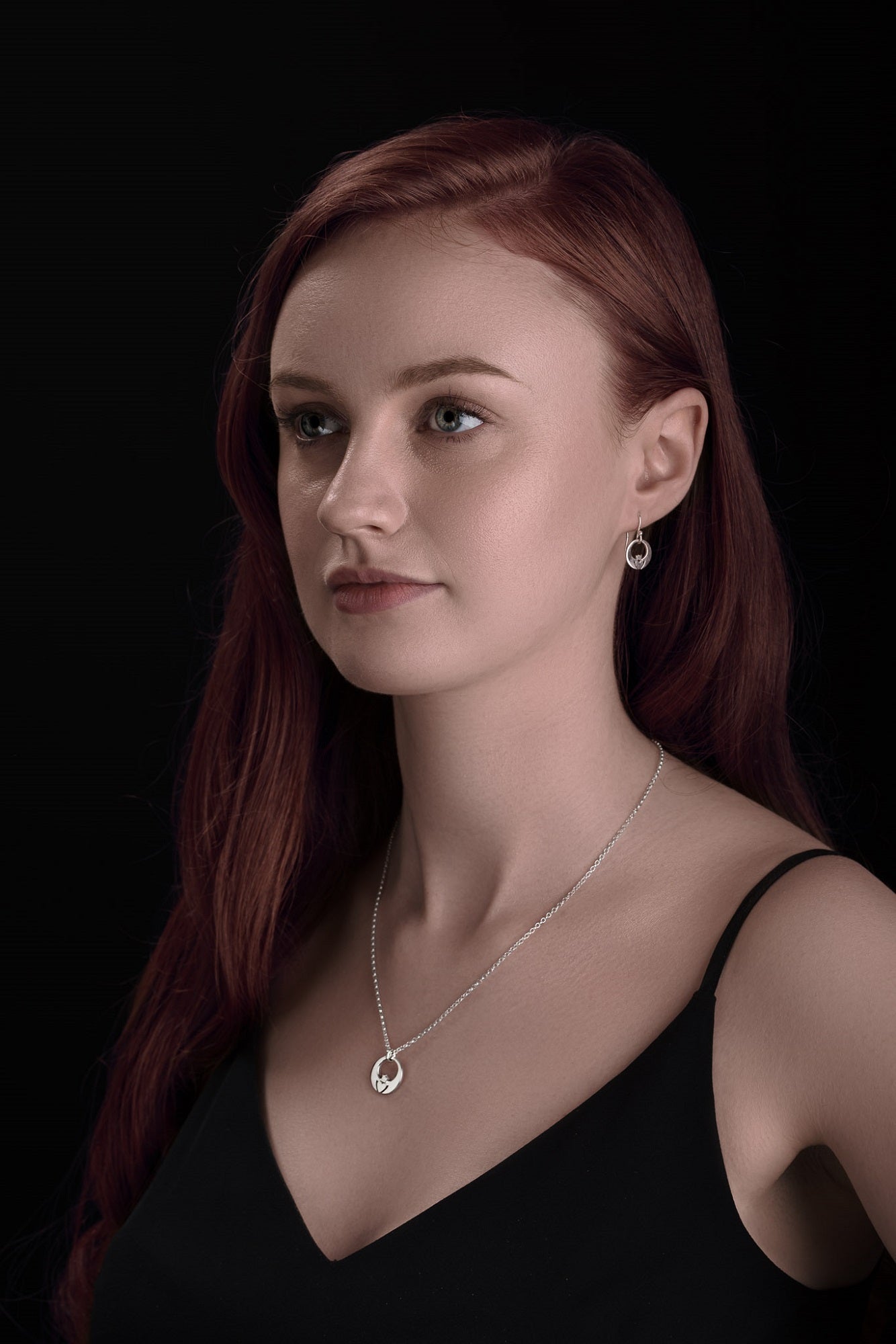 Model wears two tone Claddagh pendant made in silver with gold heart