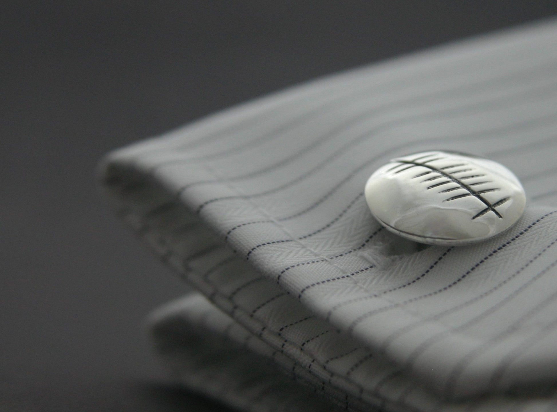 silver gra cufflinks on a grooms shirt sleeve