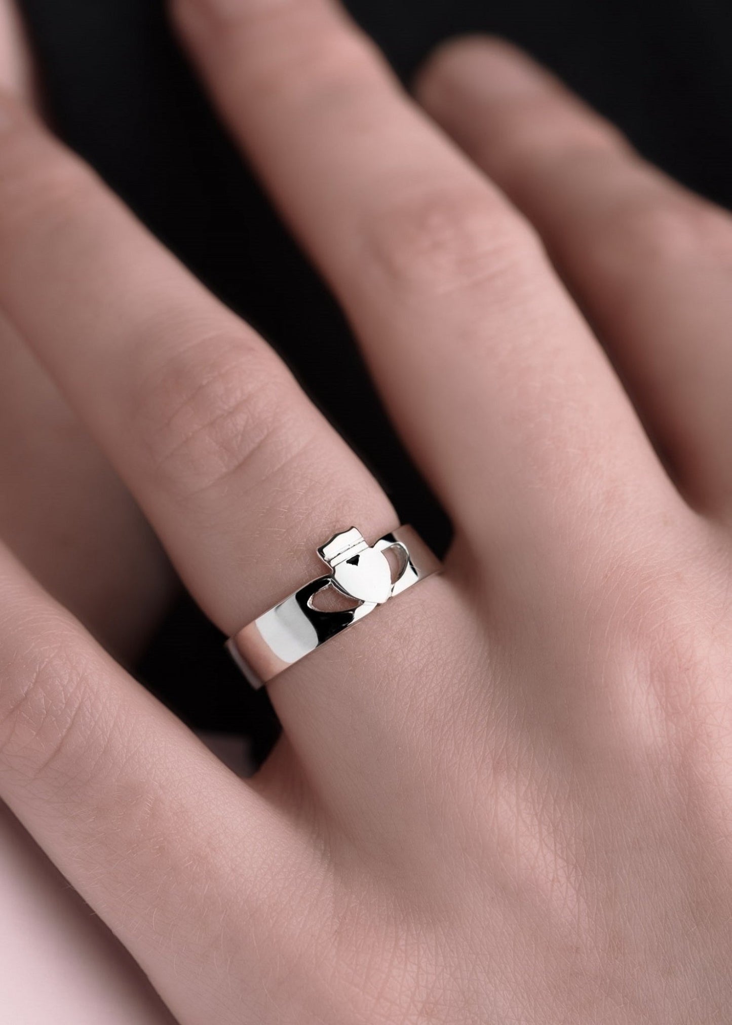 Contemporary claddagh ring in silver on models hand